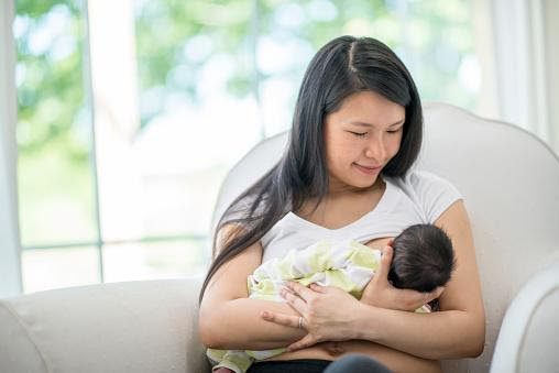 Mother peacefully breastfeeds her baby